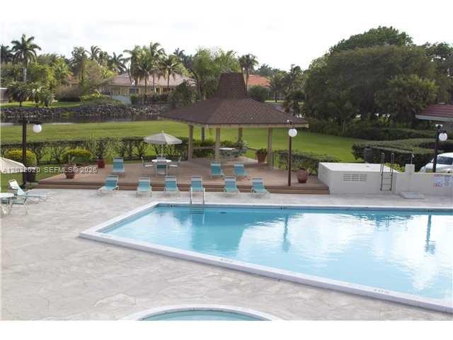 An outdoor swimming pool and a covered gazebo are situated on a paved patio area — 7956 Camino Cir # A4, Miami FL 33143, MIAMI, FL