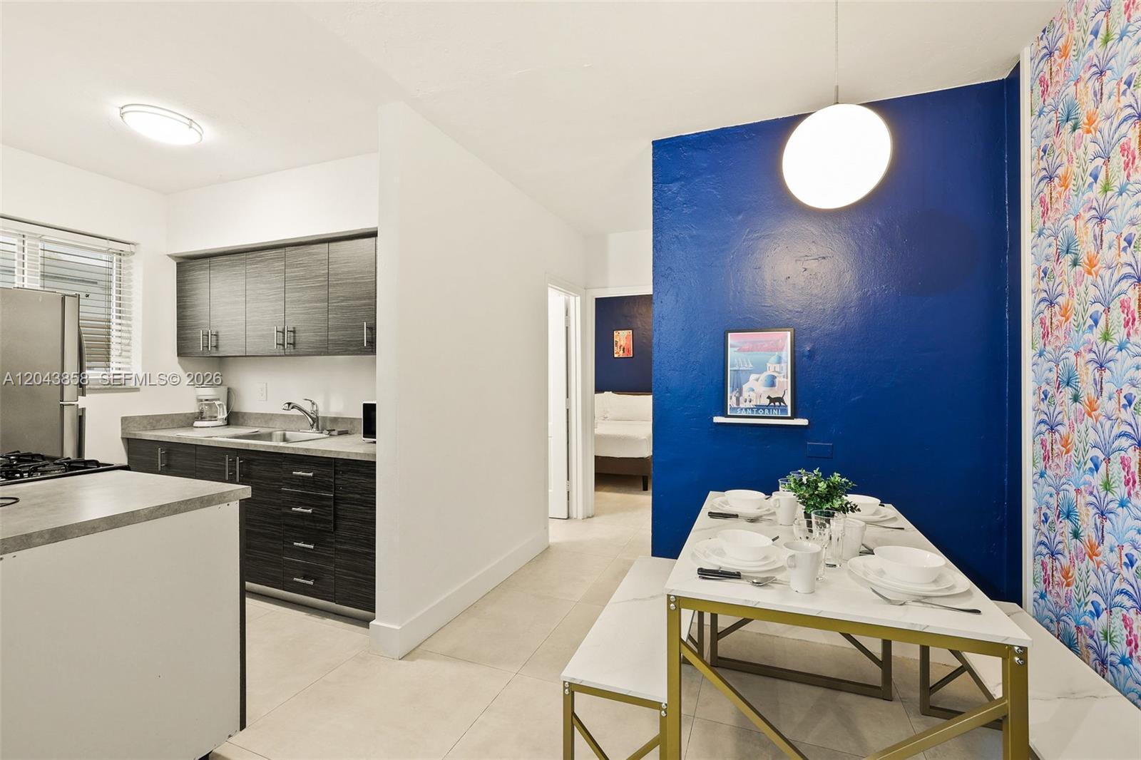 A kitchen and dining area feature dark wood cabinets, a blue accent wall, and wallpaper — 7340 Harding Ave # 4, Miami Beach FL 33141, MIAMI BEACH, FL