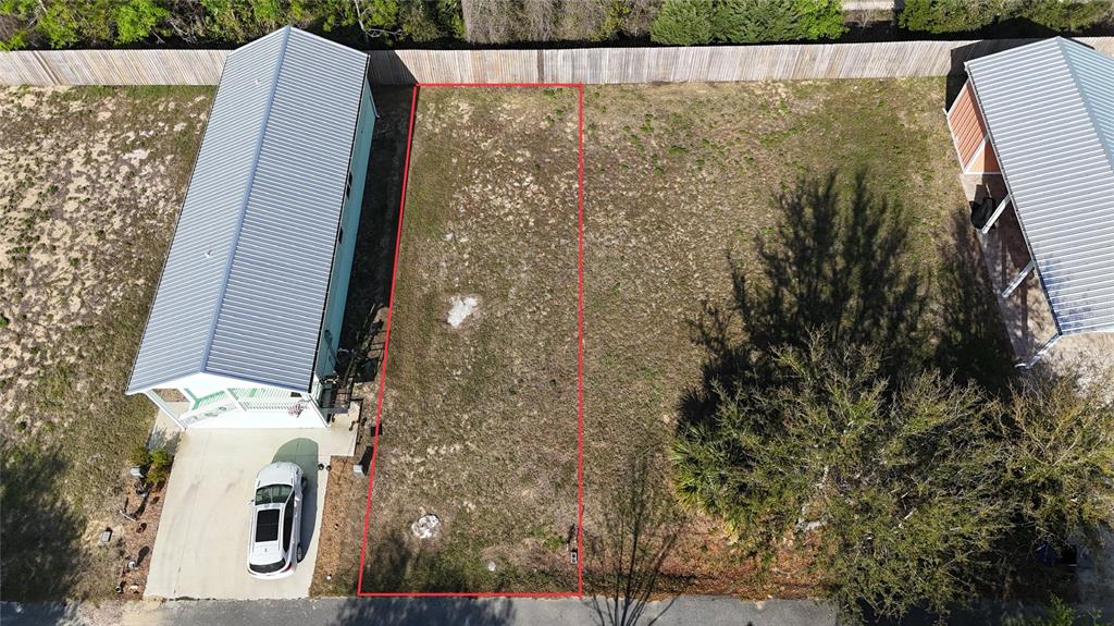 An aerial view shows a vacant rectangular lot outlined in red between two residential structures — Lot 44 SW 879TH STREET, STEINHATCHEE, FL