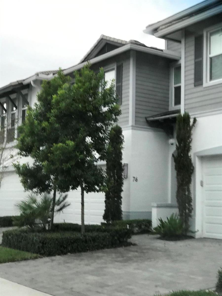 A two-story townhouse with a white stucco and gray siding exterior and a paved driveway — 23045 Clear Echo Drive # 76, Boca Raton FL 33433, BOCA RATON, FL