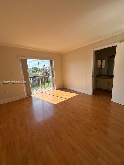 An empty bedroom with light wood flooring, a sliding glass door, and an attached bathroom — 12990 SW 63rd Ter # 605, Miami FL 33183, MIAMI, FL