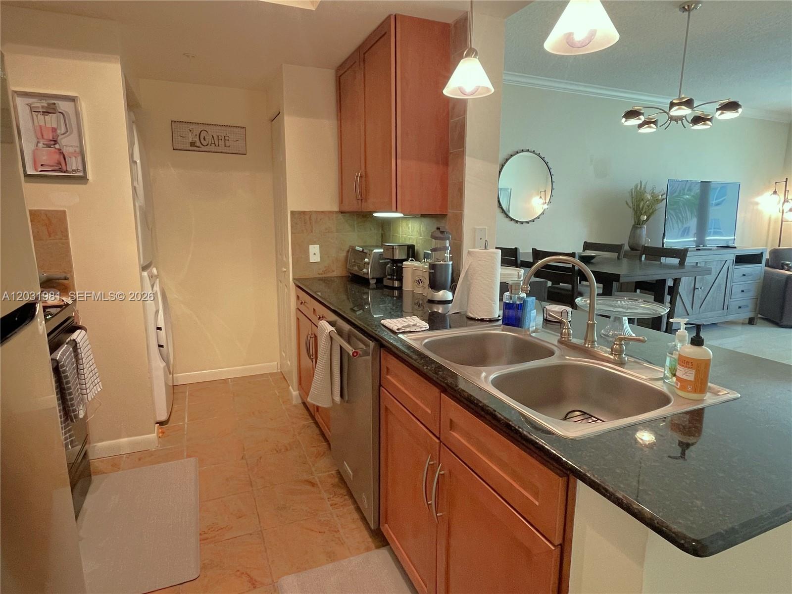 A kitchen features wood cabinets, dark granite countertops, stainless steel appliances, and tile flooring — 2000 N Bayshore Dr # 525, Miami FL 33137, MIAMI, FL