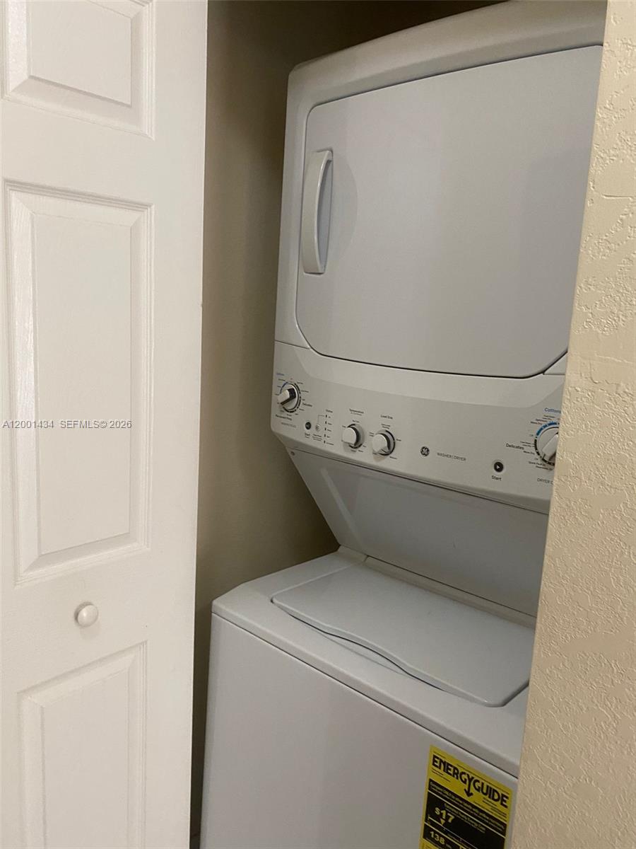 A white stacked washer and dryer unit is installed inside a small closet — 17186 SW 93RD ST # 9410, Kendall FL 33196, KENDALL, FL