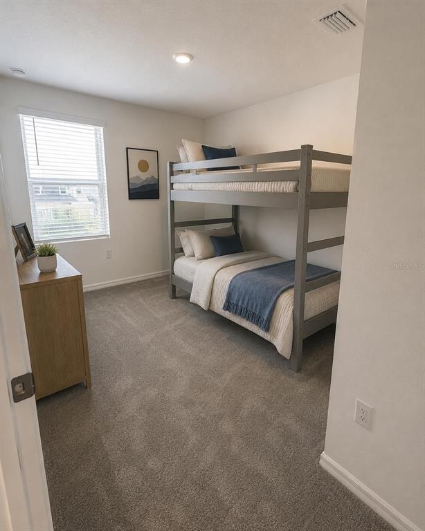 A bedroom features gray carpet, a wooden dresser, and a gray bunk bed — 8749 WINTER BREEZE WAY, SARASOTA, FL