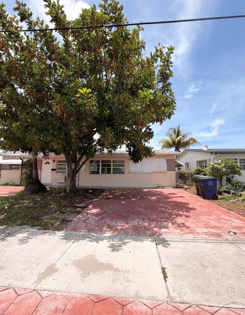 A single-story house with a large tree and a red paved driveway in front — 1077 SW 2nd St # 2, Hallandale Beach FL 33009, HALLANDALE BEACH, FL