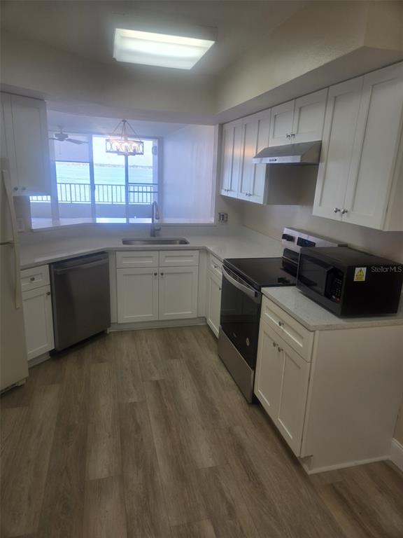 A kitchen with white cabinets, stainless steel appliances, and a window overlooking a balcony — 5153 ISLA KEY BOULEVARD S UNIT 215, ST PETERSBURG, FL