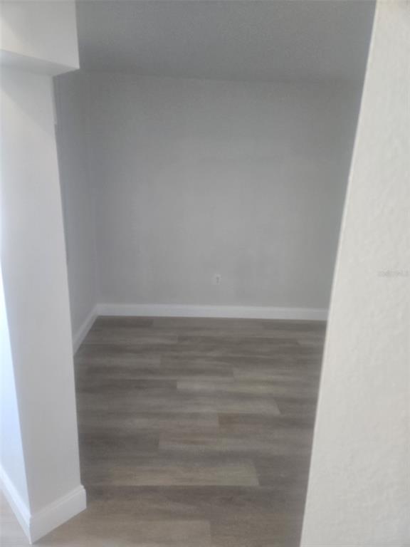 A small, empty room with light gray walls and wood-look flooring — 5153 ISLA KEY BOULEVARD S UNIT 215, ST PETERSBURG, FL