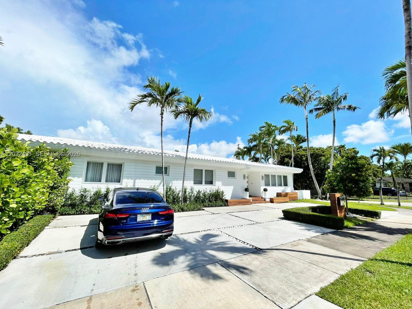 A white single-story house with a blue car parked on a concrete driveway — 290 E Shore Dr E # 290, Miami FL 33133, MIAMI, FL