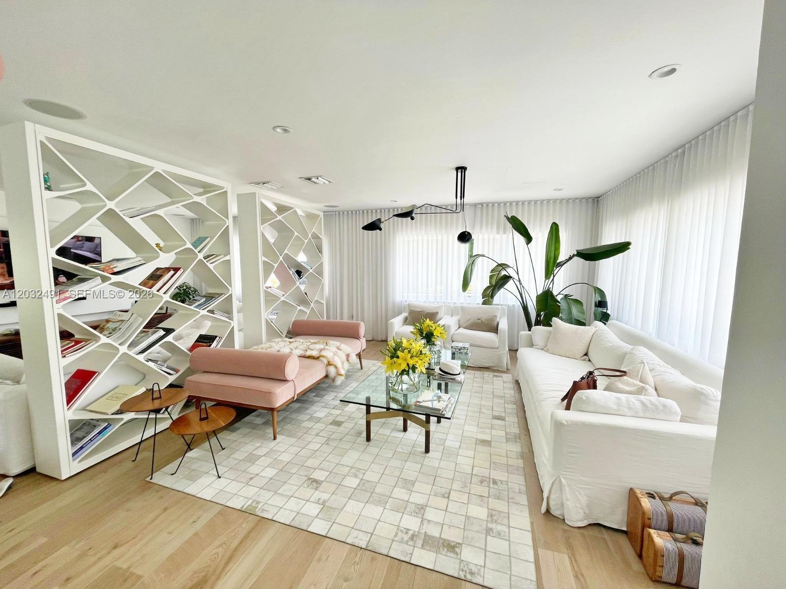 A bright living room features a white geometric bookshelf, a pink daybed, and white sofas — 290 E Shore Dr E # 290, Miami FL 33133, MIAMI, FL