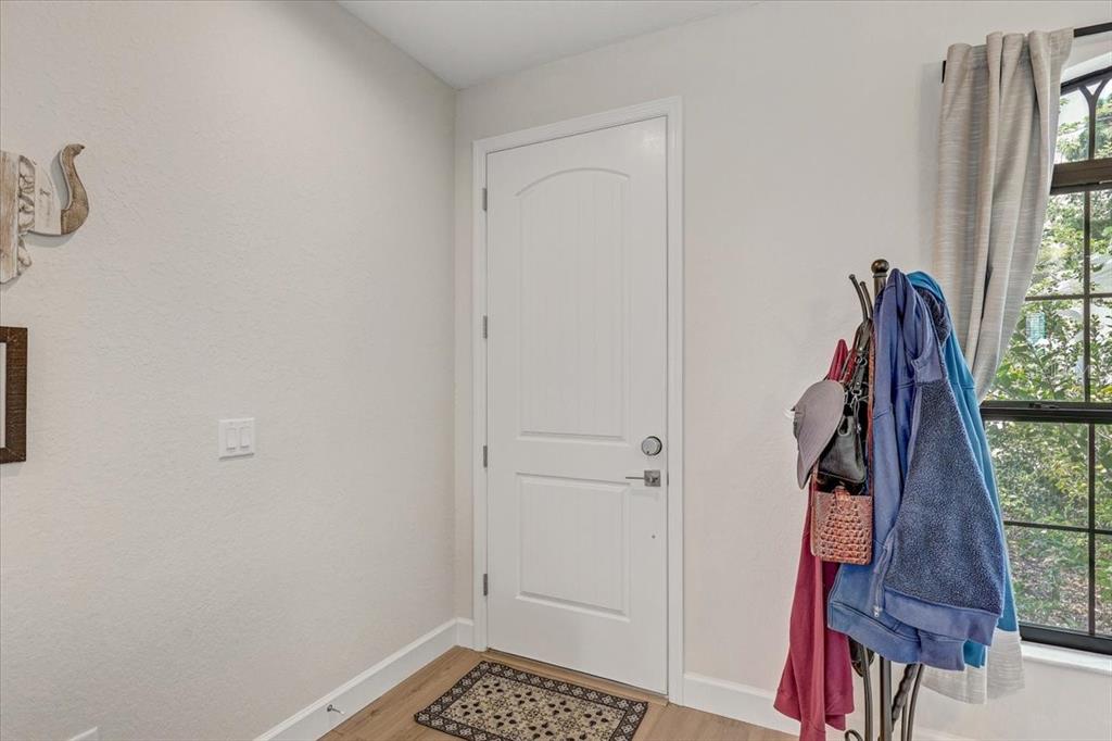 A white interior door stands in a room with light-colored walls and wood-look flooring — 7314 MADRID ROAD, WEEKI WACHEE, FL