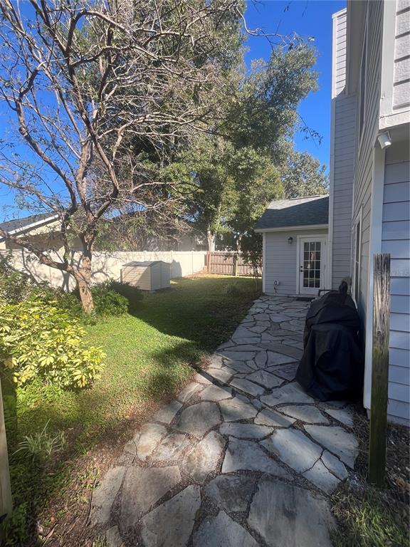 A stone path leads to a house exterior with a grill and a small shed — 1353 BLACK WILLOW TRAIL, ALTAMONTE SPRINGS, FL