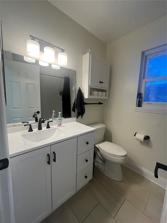 A bathroom features a white vanity with a black faucet, a mirror, and a toilet — 1353 BLACK WILLOW TRAIL, ALTAMONTE SPRINGS, FL