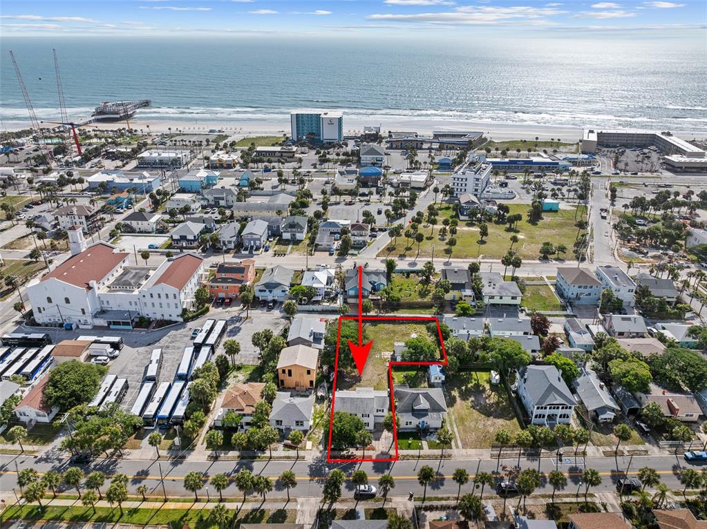 An aerial view shows a residential lot outlined in red near a beach — 129 S WILD OLIVE AVENUE, DAYTONA BEACH, FL
