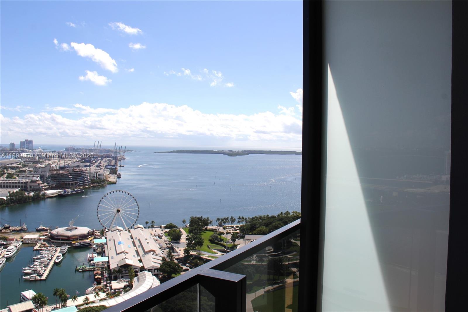 A high-rise balcony overlooks a bay, a Ferris wheel, and a marina in Miami — 398 NE 5th St # 3310, Miami FL 33132, MIAMI, FL