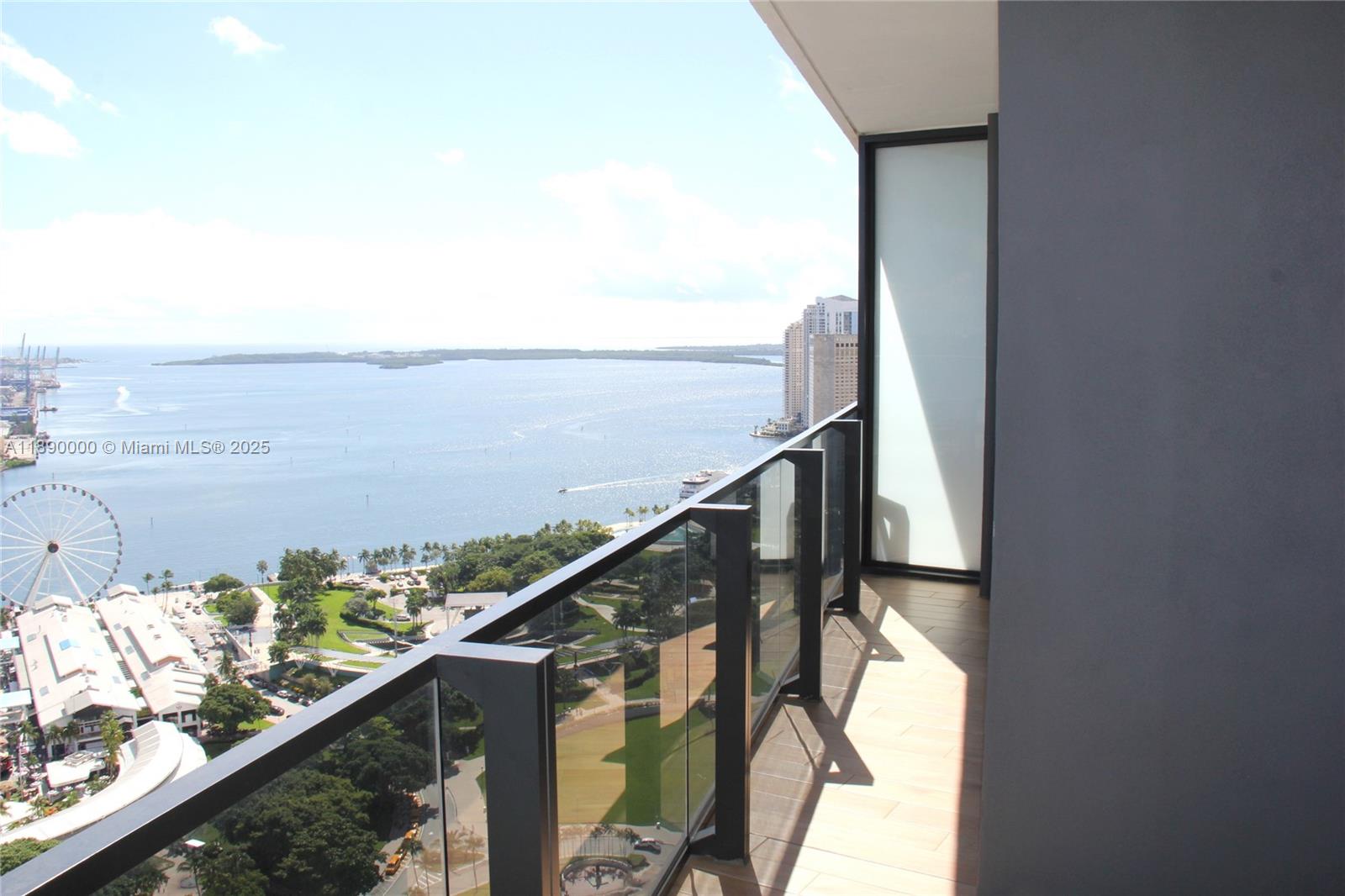 A high-rise balcony with a glass railing overlooks a bay, park, and city skyline — 398 NE 5th St # 3310, Miami FL 33132, MIAMI, FL