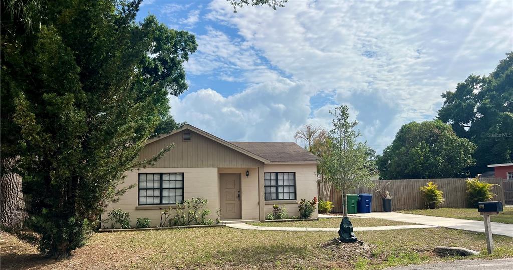 A single-story house with beige siding, a brown roof, and a front yard with trees — 3110 W IVY STREET, TAMPA, FL