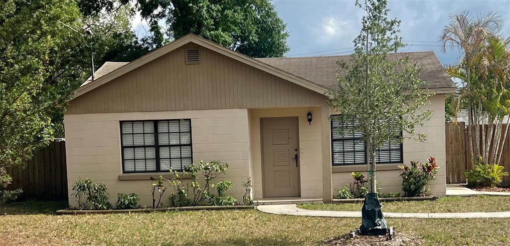 A single-story house with a beige block exterior, brown siding, and a front-facing entrance — 3110 W IVY STREET, TAMPA, FL