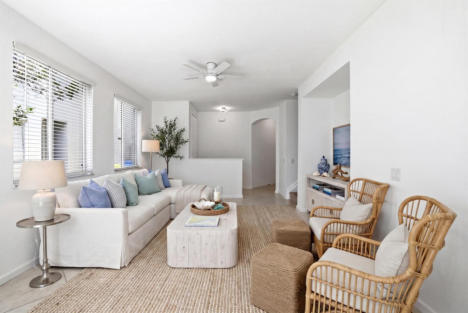 A bright living room features a white sectional sofa, two rattan chairs, and a coffee table — 3068 Laurel Ridge Circle, Riviera Beach FL 33404, RIVIERA BEACH, FL