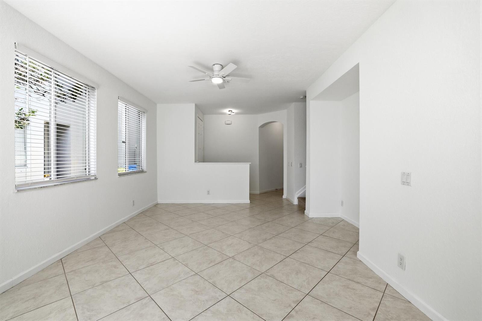 An empty room with white walls, tile flooring, two windows with blinds, and a ceiling fan — 3068 Laurel Ridge Circle, Riviera Beach FL 33404, RIVIERA BEACH, FL