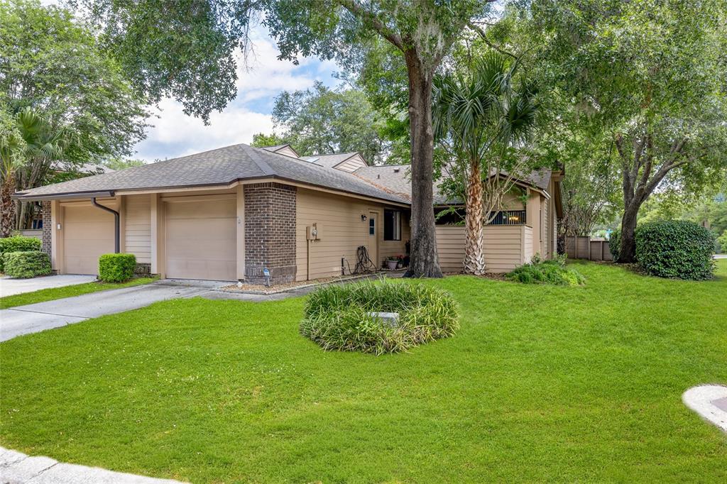 A single-story house with a two-car garage, tan siding, and a brick accent wall — 601 ALBANY COURT, LONGWOOD, FL