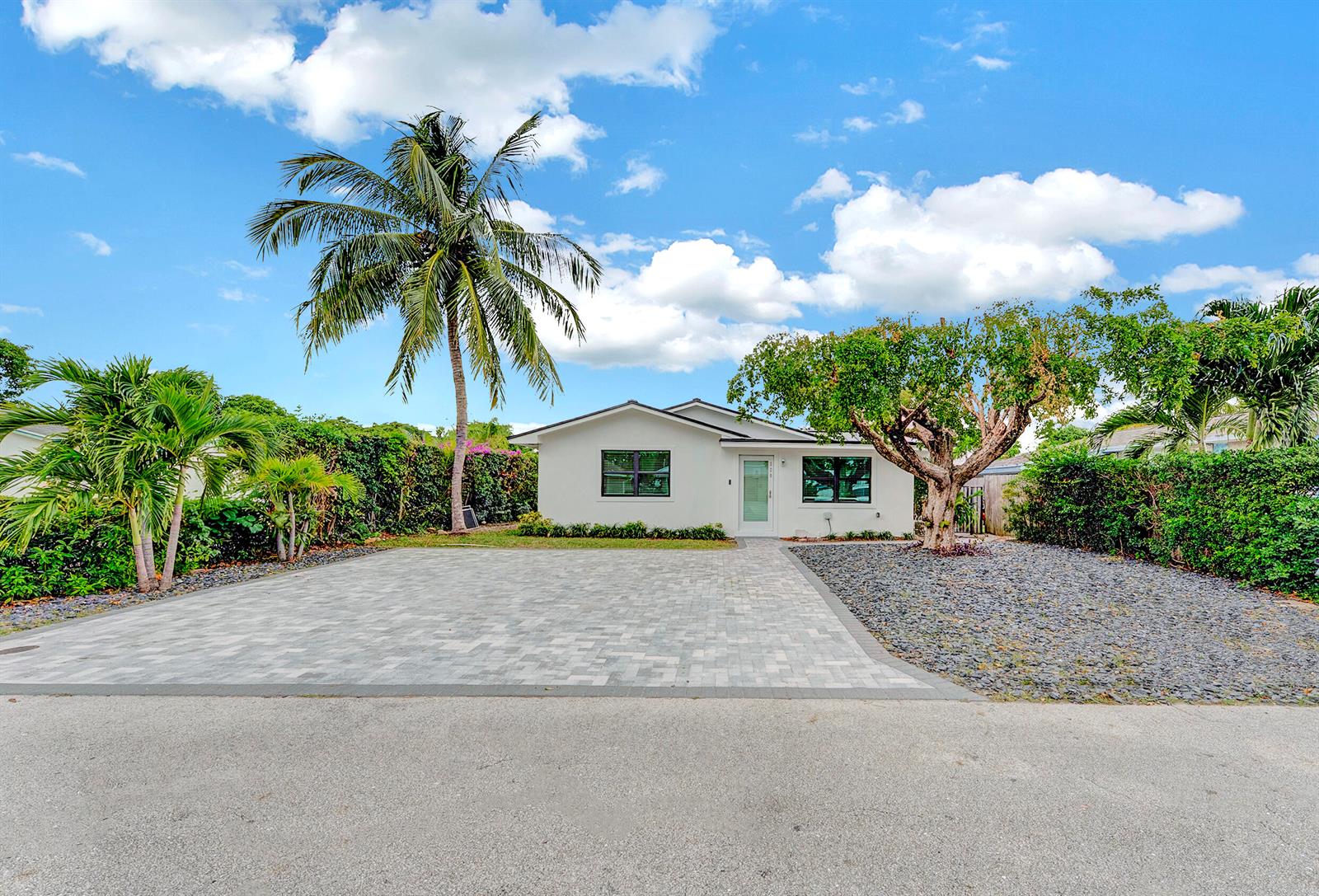 A white single-story house features a paved driveway, palm tree, and a gravel front yard — 320 NW 3rd Avenue, Delray Beach FL 33444, DELRAY BEACH, FL