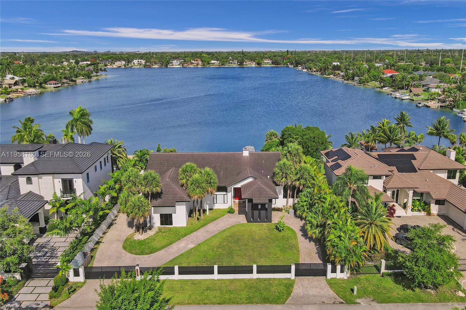 An aerial view shows a house with a dark roof, palm trees, and a lake — 13724 SW 92nd Ct, Miami FL 33176, MIAMI, FL