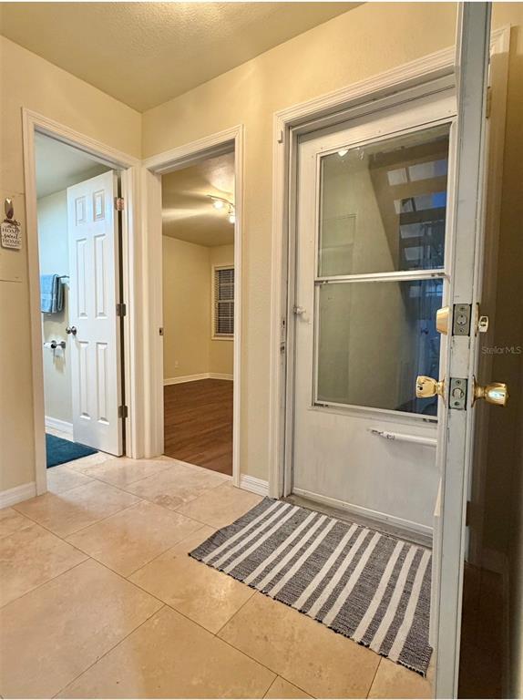 An interior view shows a tiled entryway with a doorway, a hallway, and a glass door — 3815 N OAK DRIVE UNIT G71, TAMPA, FL