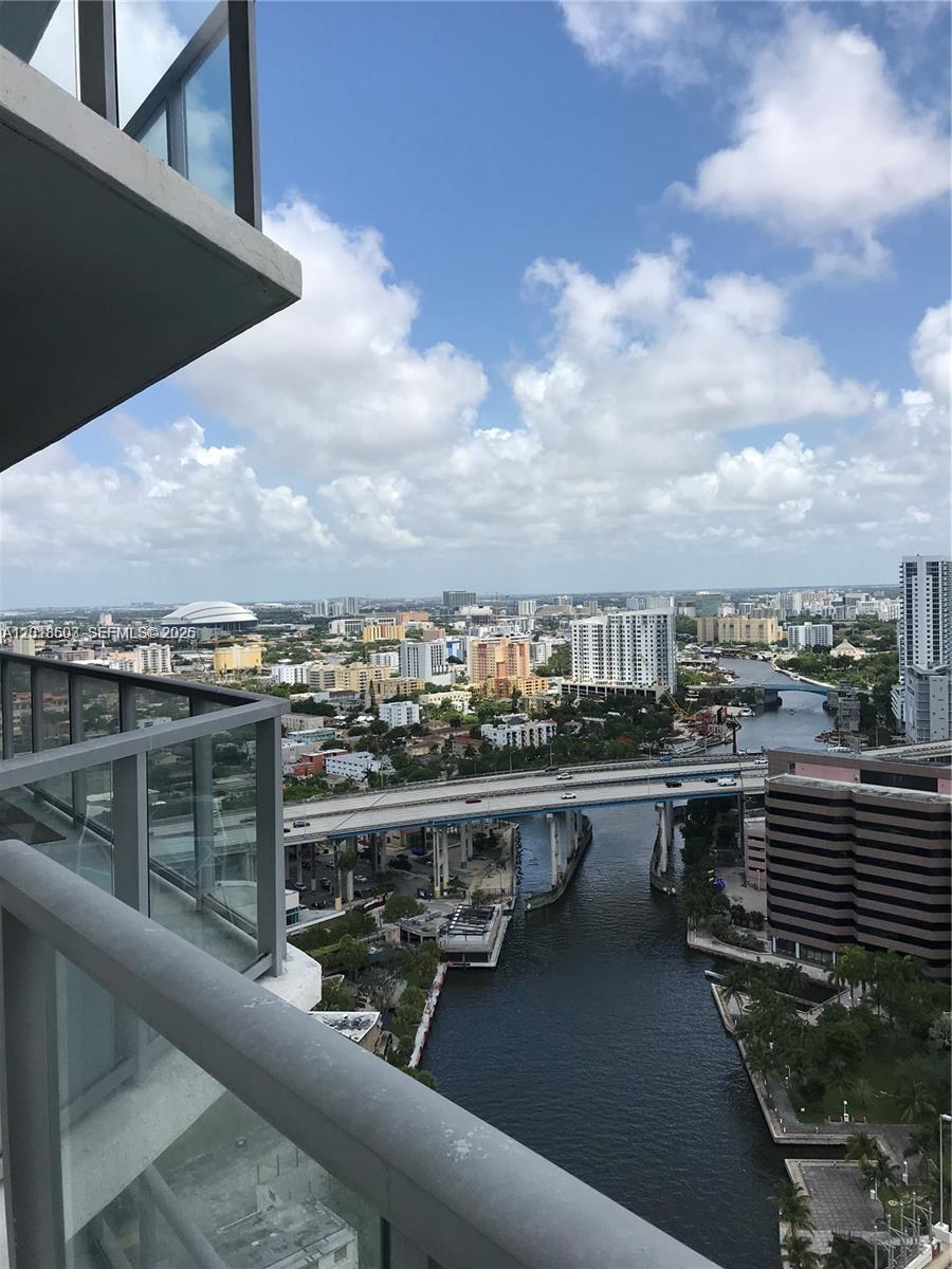 A high-angle view from a balcony overlooks a river, a highway bridge, and city buildings — 185 SW 7th St # 2805, Miami FL 33130, MIAMI, FL