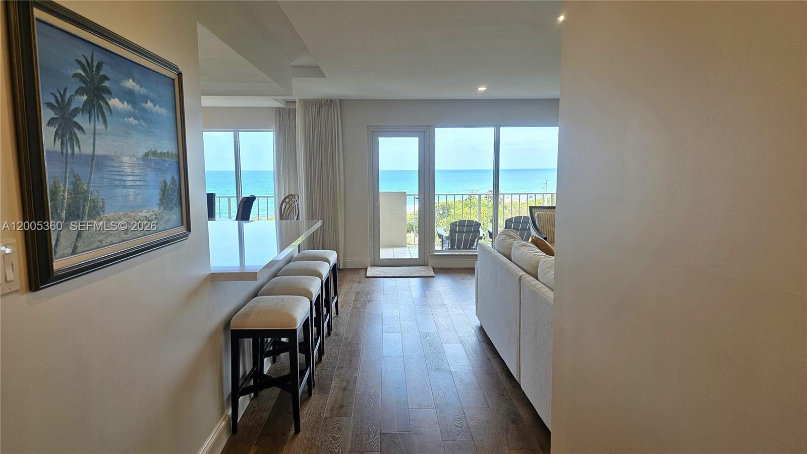 A kitchen island with bar stools overlooks a living area with ocean views — 4001 N Ocean Blvd # 702, Boca Raton FL 33431, BOCA RATON, FL