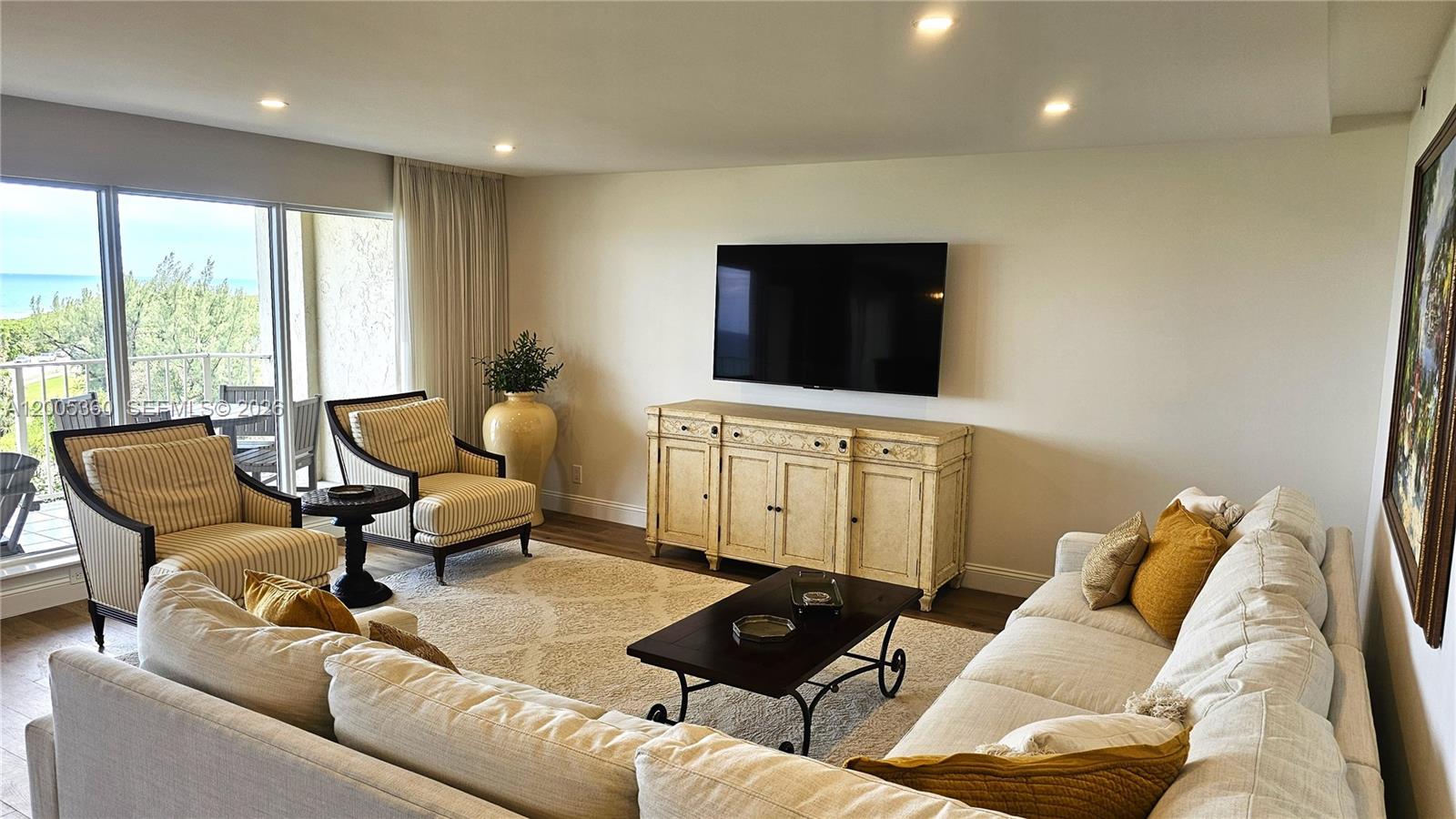 A living room features a large sectional sofa, two armchairs, a television, and a balcony — 4001 N Ocean Blvd # 702, Boca Raton FL 33431, BOCA RATON, FL