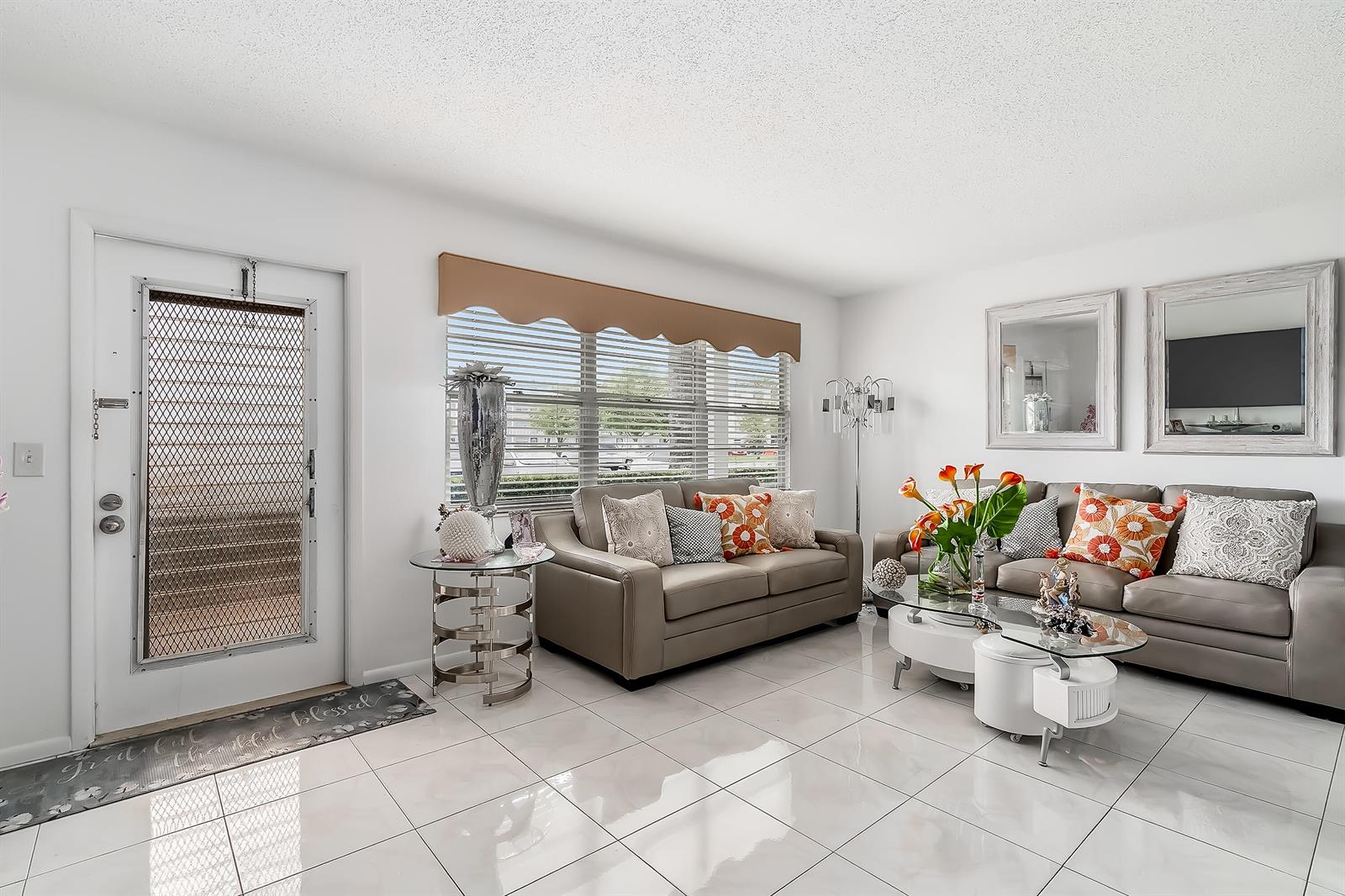 A living room features white tile floors, gray leather sofas, and a large window — 1012 Lincoln # 1012, Boca Raton FL 33434, BOCA RATON, FL