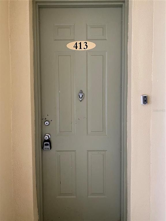 A light green apartment door with the number 413, a door knocker, and a lockbox — 413 TERRACE RIDGE CIRCLE UNIT 413, DAVENPORT, FL