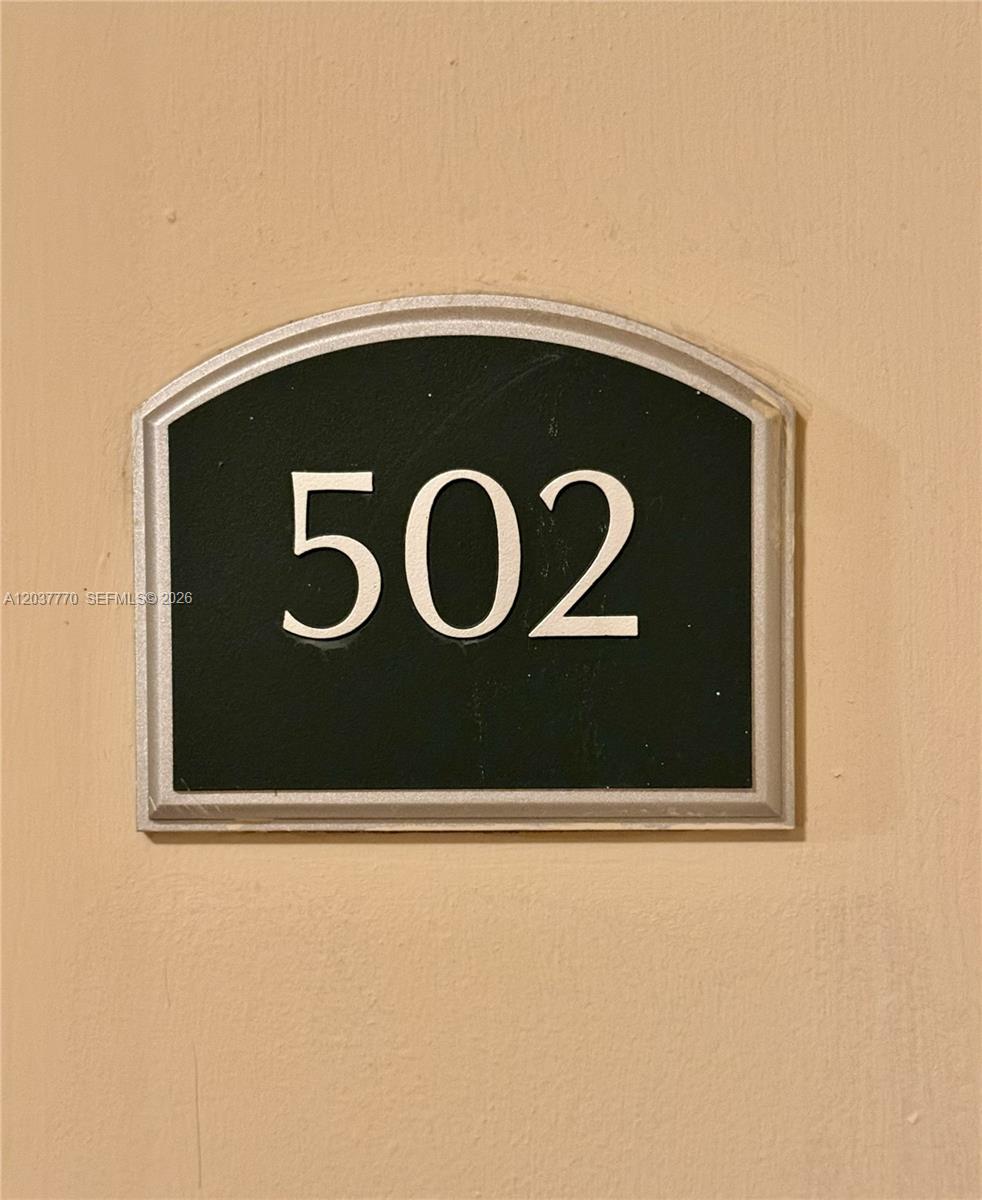 A black sign with the white number 502 is mounted on a beige wall — 1690 SW 27th Ave # 502, Miami FL 33145, MIAMI, FL