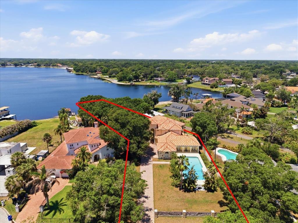 An aerial view shows a waterfront house with a pool and a red-outlined property boundary — 12006 WATERSIDE COURT, TAMPA, FL
