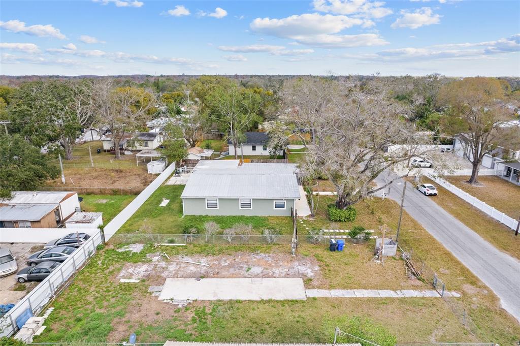 An aerial view shows a single-story house with a metal roof and a large yard — 12912 CAMBRIDGE AVENUE, TAMPA, FL