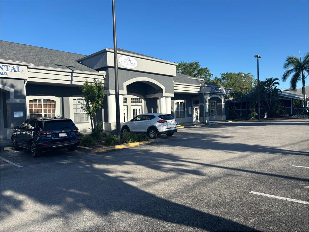 A commercial building with a gray facade, parking lot, and a white SUV parked outside — 2855 ALT 19, PALM HARBOR, FL
