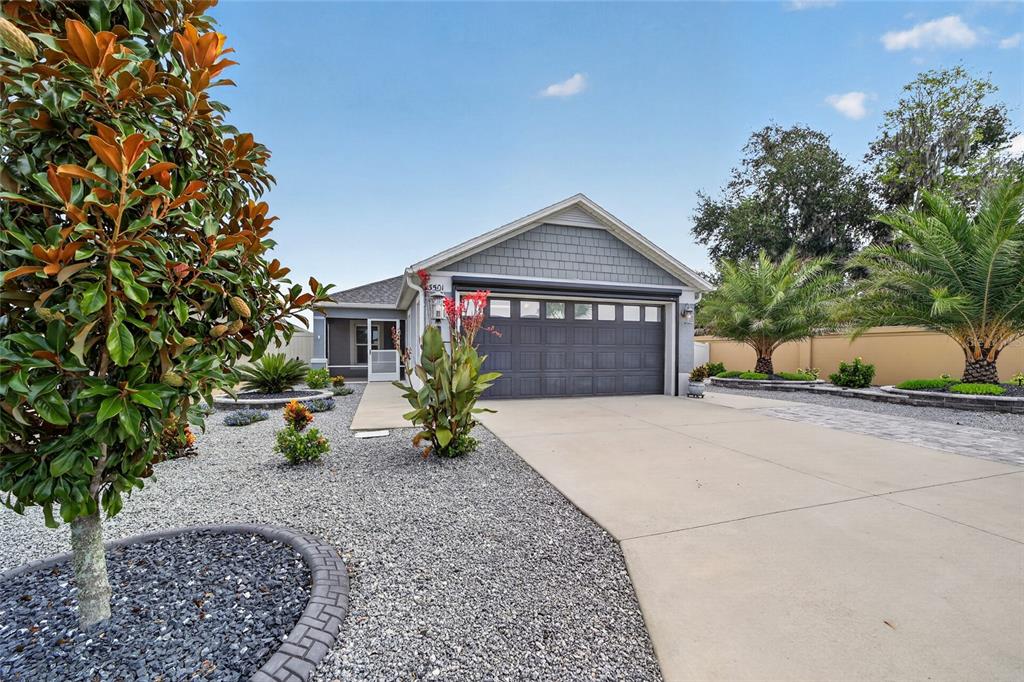 A single-story house with a gray garage, a concrete driveway, and landscaped gravel front yard — 3501 CONNOR WAY, THE VILLAGES, FL