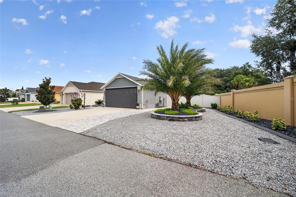 A single-story house with a gray garage, a palm tree, and a gravel front yard — 3501 CONNOR WAY, THE VILLAGES, FL