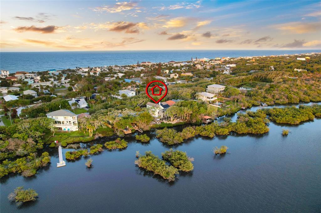 An aerial view shows a house with a red marker located near a coastal waterway — 1004 S FLAGLER AVENUE, FLAGLER BEACH, FL