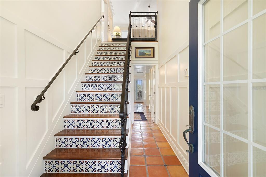 An entryway features a staircase with patterned tile risers and a terracotta-tiled floor — 1004 S FLAGLER AVENUE, FLAGLER BEACH, FL