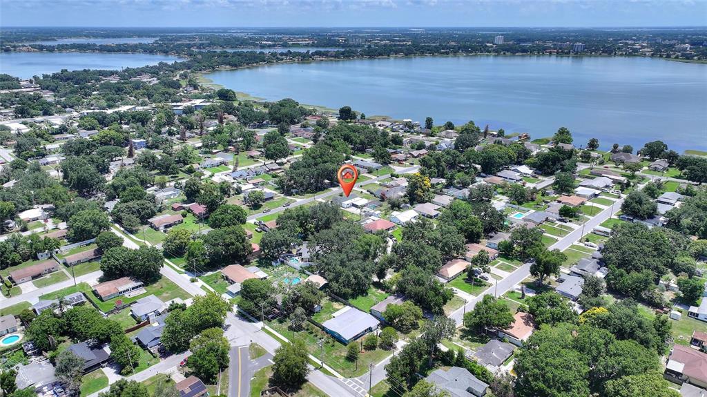 An aerial view shows a residential neighborhood with a lake in the background — 2230 W CENTRAL AVENUE, WINTER HAVEN, FL