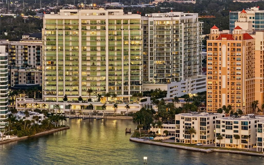 An aerial view of waterfront high-rise apartment buildings and a canal in a coastal city — 401 QUAY COMMONS UNIT 1501, SARASOTA, FL
