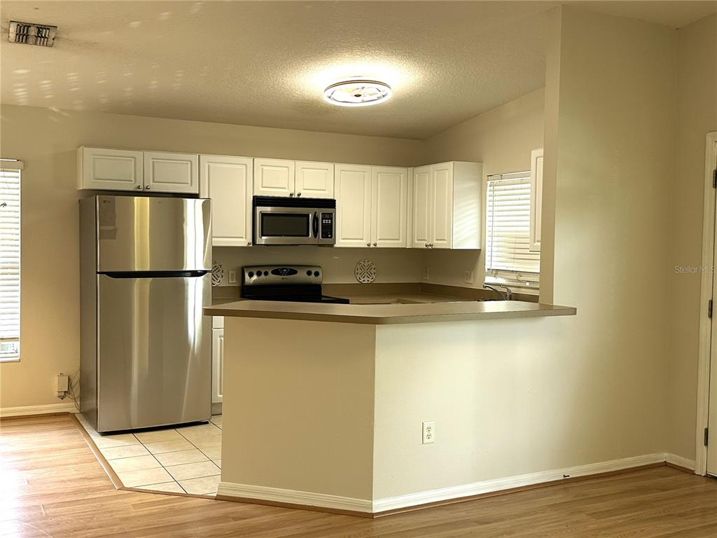 A kitchen features white cabinets, stainless steel appliances, and a breakfast bar — 1717 W NASSAU STREET UNIT A, TAMPA, FL