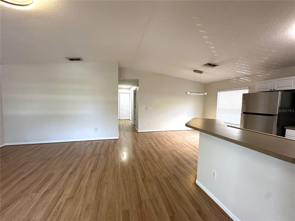 An open-concept living area features light wood-look flooring and a kitchen with a breakfast bar — 1717 W NASSAU STREET UNIT A, TAMPA, FL