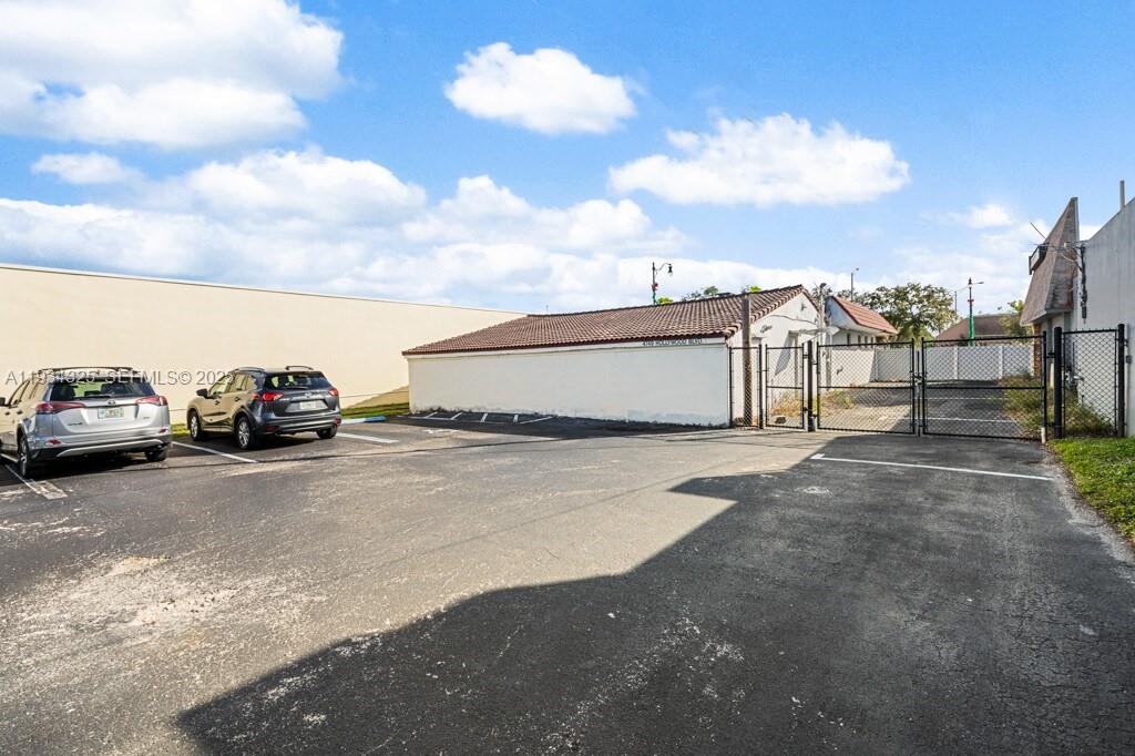 An asphalt parking lot sits in front of a single-story building with a gated entrance — 4749 Hollywood Blvd, Hollywood FL 33021, HOLLYWOOD, FL