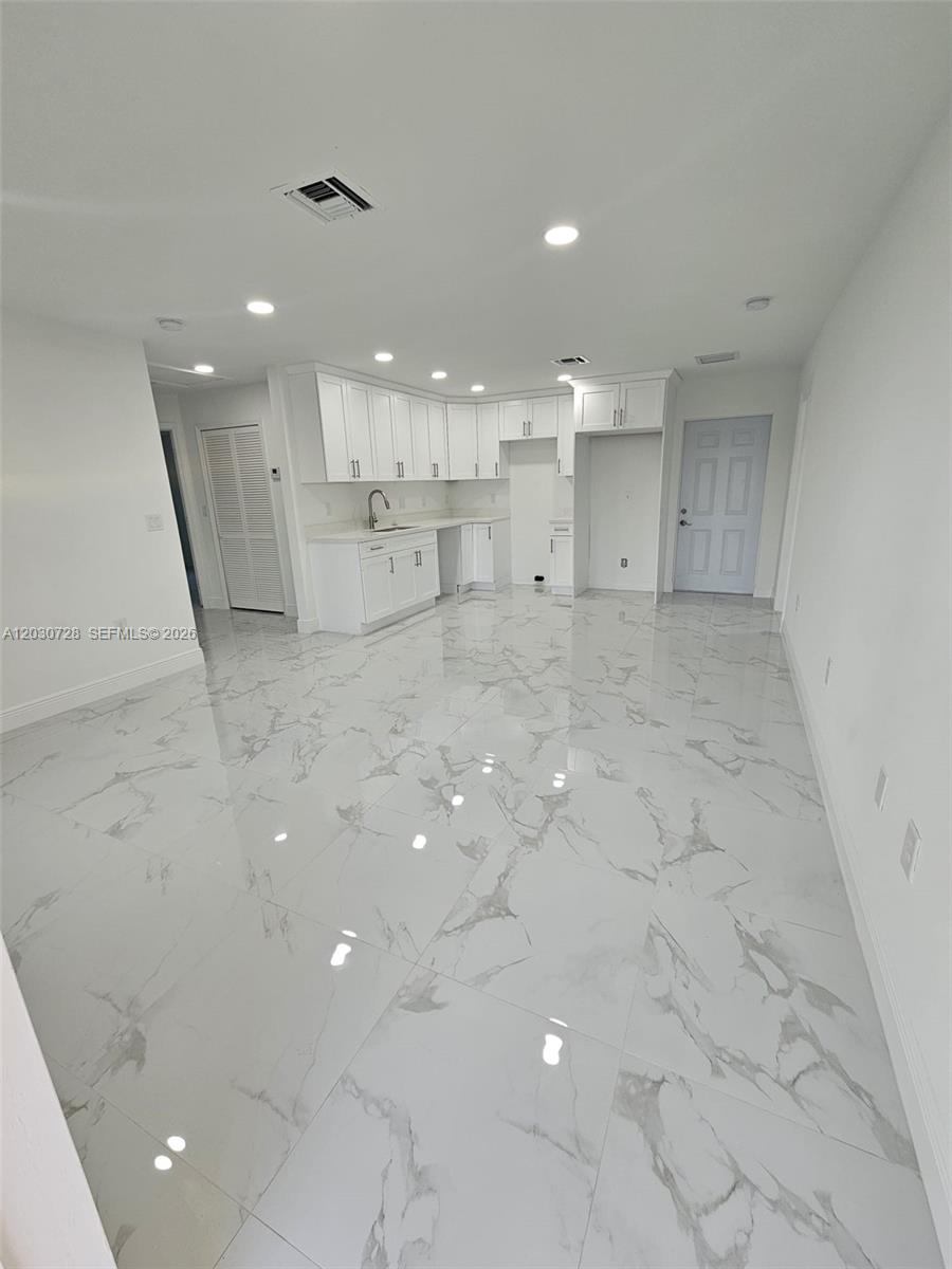 A kitchen with white cabinets, marble-patterned tile floors, and recessed lighting — 3819 3rd st W, Lehigh Acres FL 33971, LEHIGH ACRES, FL