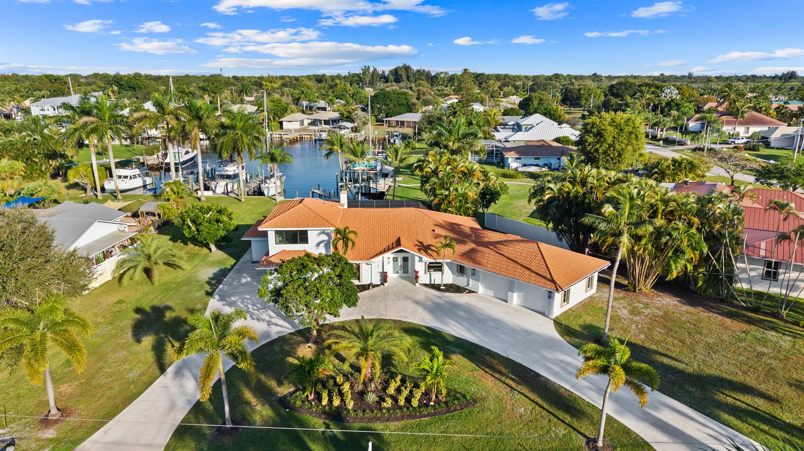 An aerial view shows a single-story house with a terracotta roof and a circular driveway — 2807 NW St Lucie Lane, Stuart FL 34994, STUART, FL