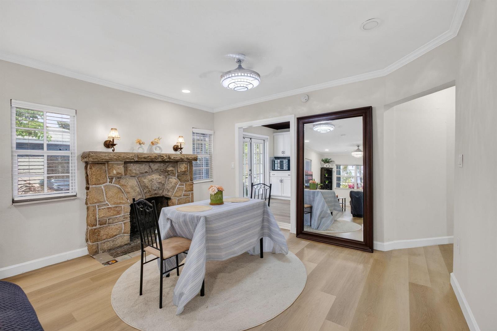 A dining room features a stone fireplace, a large floor mirror, and light wood flooring — 1314 N J Street, FL 33460, FL