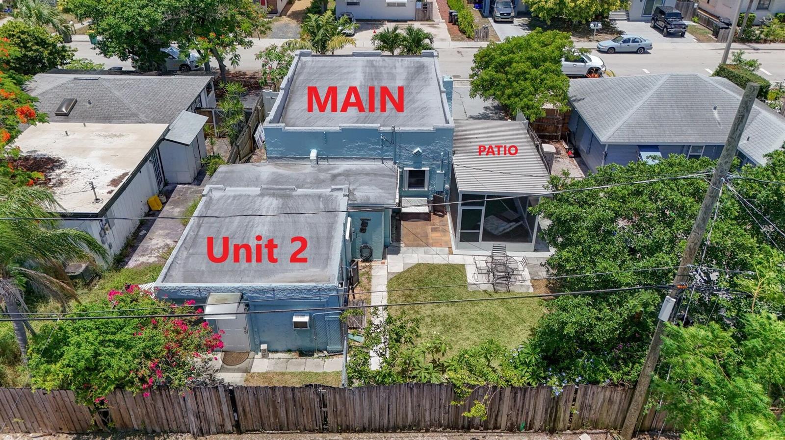 An aerial view shows a blue house with a main structure, a detached unit, and patio — 1314 N J Street, FL 33460, FL