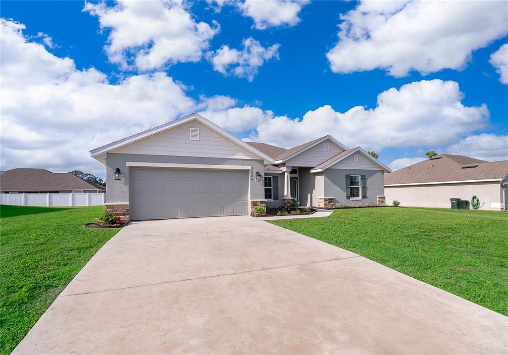 A single-story suburban house with a gray garage, light siding, and a concrete driveway — 226 NW 44TH STREET, OCALA, FL